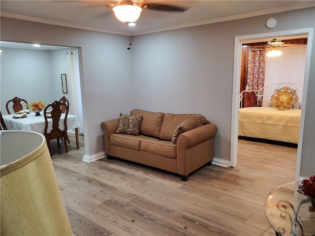 living room with light hardwood / wood-style floors, ceiling fan, and ornamental molding