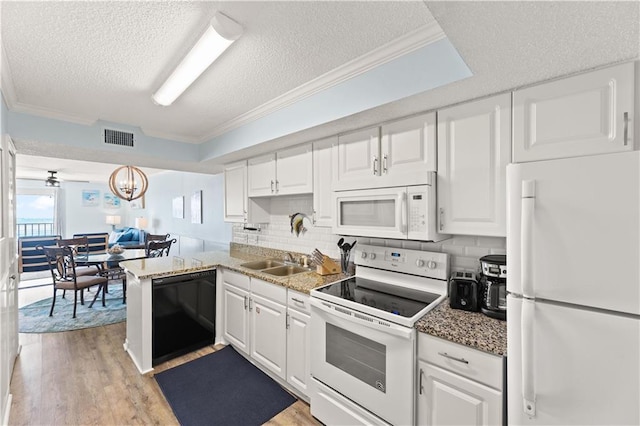 kitchen featuring white appliances, decorative backsplash, a textured ceiling, white cabinetry, and sink