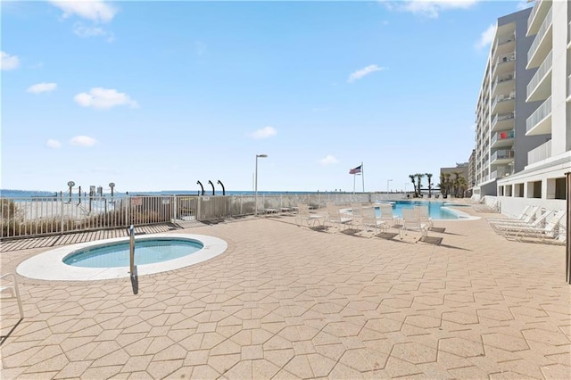 view of swimming pool with a patio area and a water view