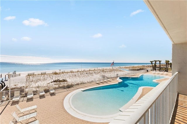 view of pool featuring a beach view and a water view