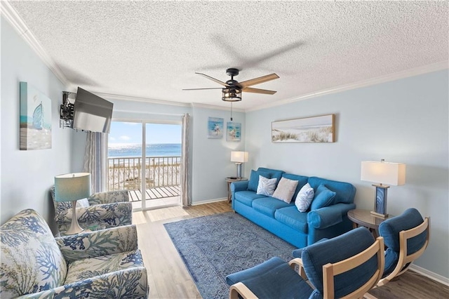 living room featuring a textured ceiling, ceiling fan, crown molding, and light hardwood / wood-style floors