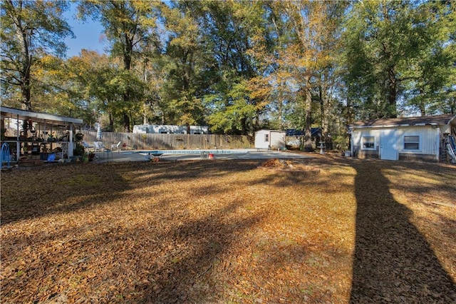 view of yard with an empty pool and a shed