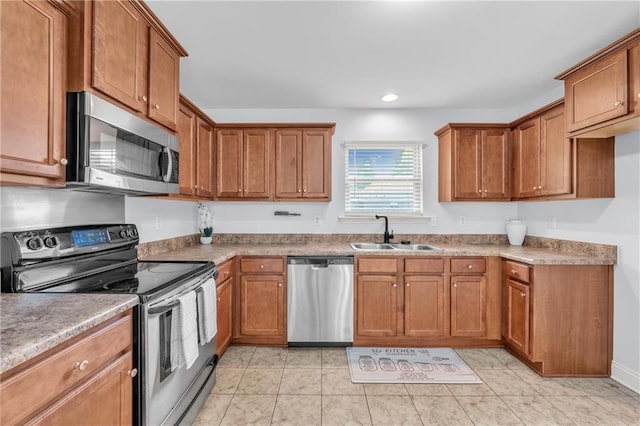 2107 Wolf Branch Dr N, Mobile, AL 36608 - kitchen with stainless steel appliances, a sink, brown cabinetry, recessed lighting, and light tile patterned floors