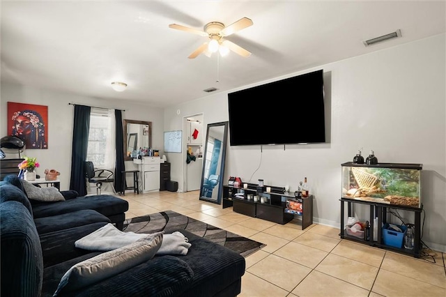 living area featuring baseboards, light tile patterned flooring, visible vents, and a ceiling fan