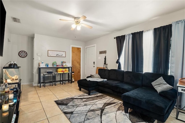 tiled living room featuring a ceiling fan, visible vents, and baseboards