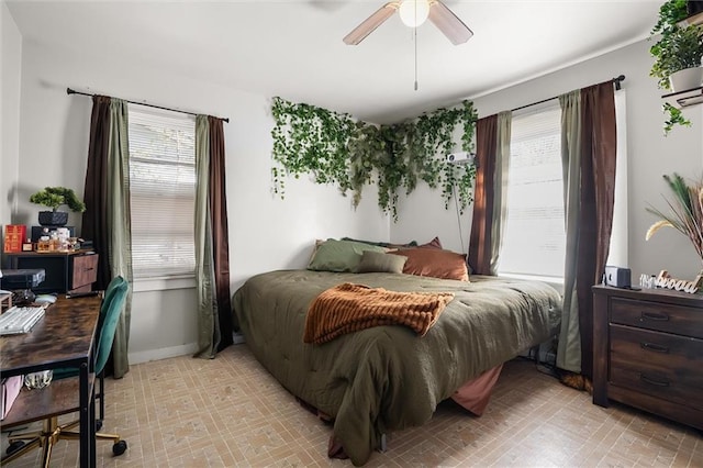 bedroom with a ceiling fan and baseboards