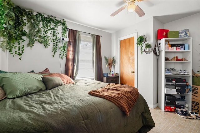 bedroom with brick floor and a ceiling fan