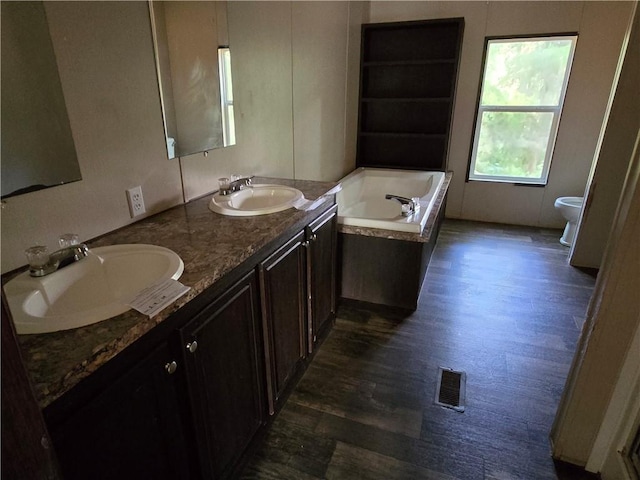 bathroom with a bathtub, hardwood / wood-style flooring, toilet, and vanity