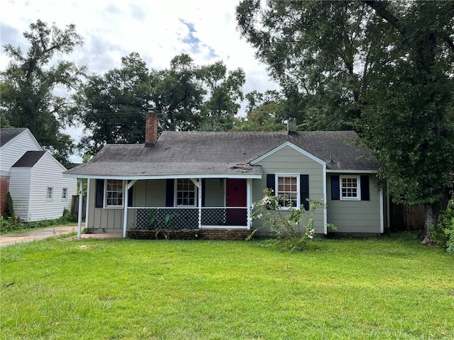 single story home featuring a chimney, roof with shingles, covered porch, board and batten siding, and a front yard