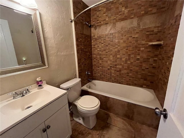 full bathroom featuring tiled shower / bath combo, vanity, toilet, and tile patterned flooring