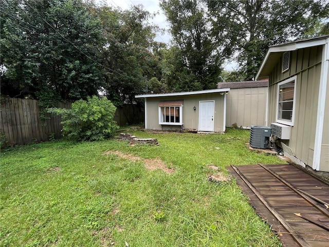 view of yard with cooling unit and an outbuilding