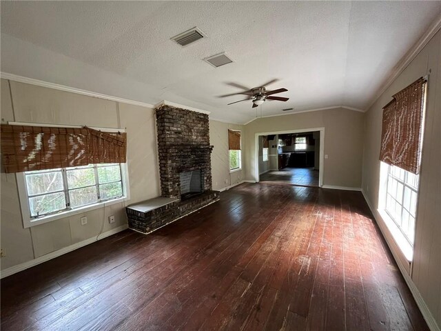 unfurnished living room featuring ornamental molding, dark hardwood / wood-style flooring, a brick fireplace, ceiling fan, and lofted ceiling