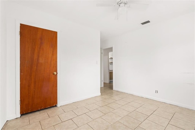 spare room with ceiling fan and light tile patterned flooring