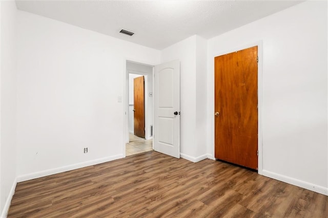 unfurnished room with wood-type flooring