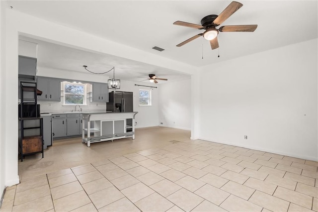 living room featuring sink, light tile patterned floors, and ceiling fan