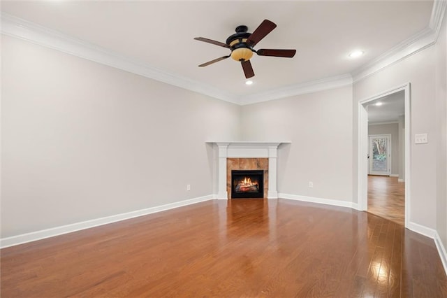 unfurnished living room featuring crown molding, ceiling fan, dark hardwood / wood-style floors, and a tile fireplace