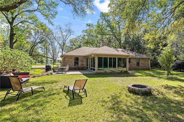 10407 Lala Rd, Daphne, AL 36526 - rear view of property featuring a patio area, a fire pit, a yard, and a sunroom