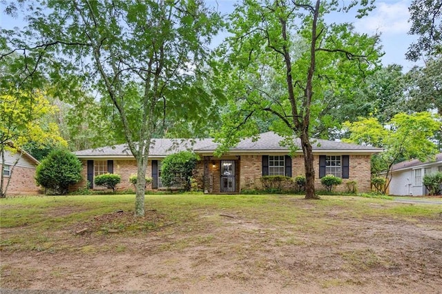 ranch-style house featuring brick siding and a front lawn