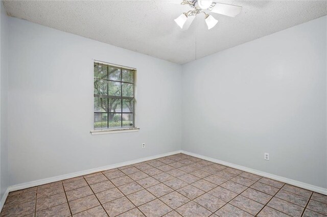 unfurnished room with a textured ceiling, light tile patterned floors, and ceiling fan