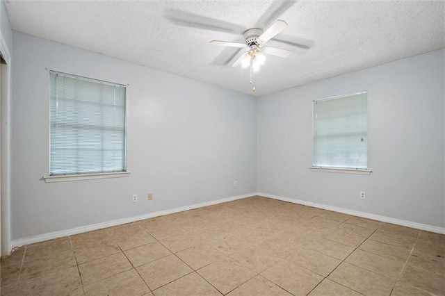 tiled empty room featuring baseboards, a textured ceiling, and a ceiling fan