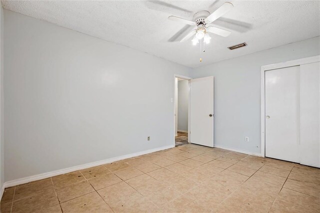 unfurnished bedroom featuring ceiling fan and a textured ceiling