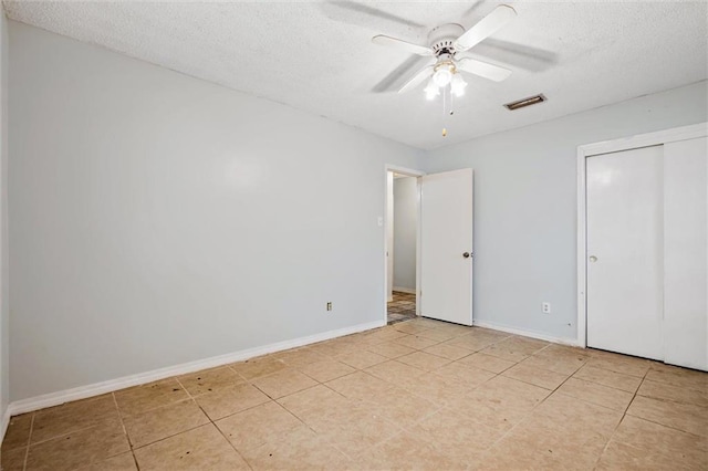 unfurnished bedroom with visible vents, baseboards, a textured ceiling, and a ceiling fan