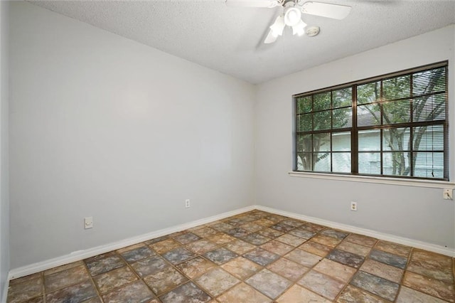 unfurnished room featuring ceiling fan, a textured ceiling, and baseboards