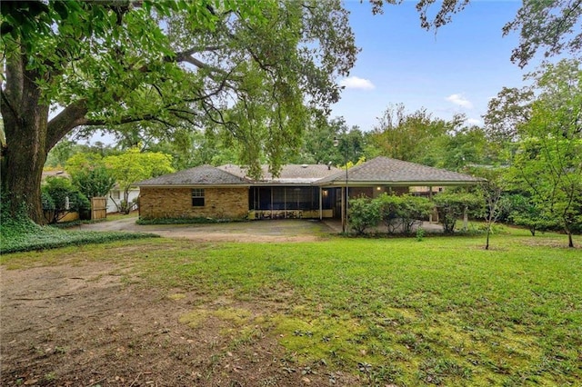 back of property featuring a lawn and a sunroom