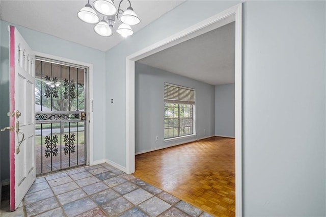 doorway with light parquet flooring and a chandelier