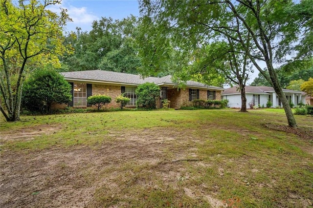 ranch-style home featuring a front lawn and brick siding