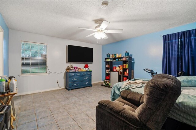 living room with a textured ceiling, ceiling fan, and light tile patterned flooring