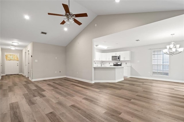 4625 Pine Blvd, Orange Beach, AL 36561 - unfurnished living room with ceiling fan, a chandelier, light wood-style flooring, high vaulted ceiling, and baseboards