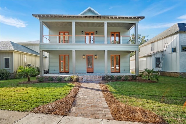 view of front of house featuring a front lawn, covered porch, and a balcony