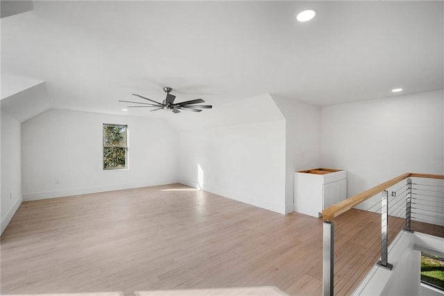 additional living space featuring light hardwood / wood-style floors, a healthy amount of sunlight, vaulted ceiling, and ceiling fan