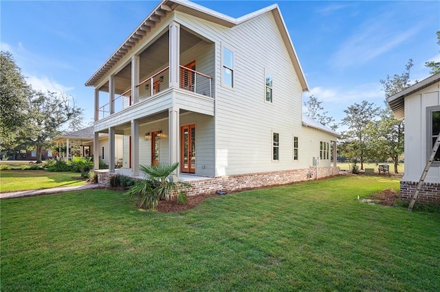 view of side of property featuring a balcony and a yard