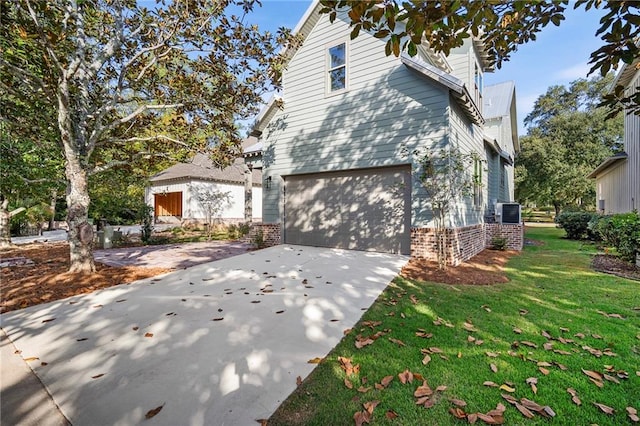 view of home's exterior with a garage and a lawn