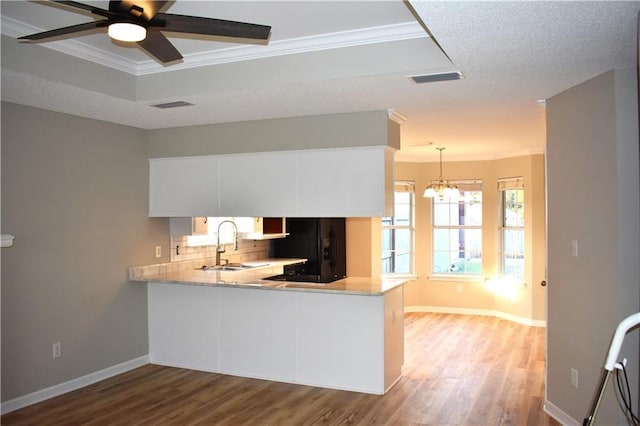 kitchen featuring white cabinets, black fridge with ice dispenser, kitchen peninsula, and light wood-type flooring