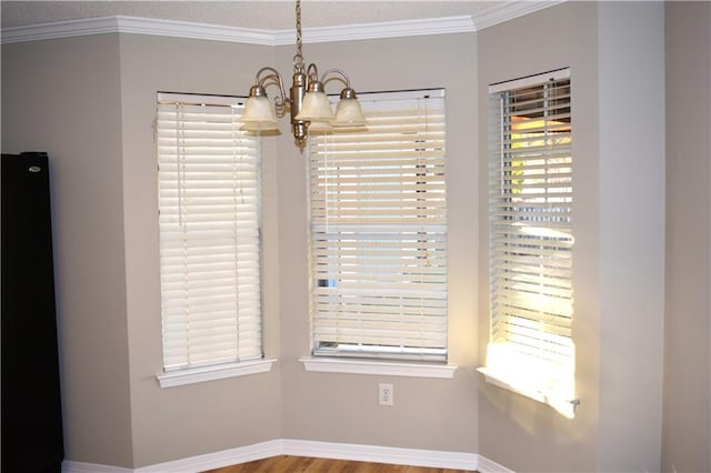 interior space with a chandelier, a textured ceiling, hardwood / wood-style flooring, and ornamental molding