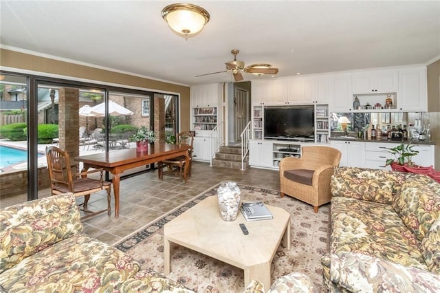 living area with stairway, ceiling fan, and crown molding