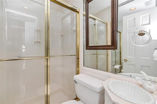 bathroom with toilet, visible vents, vanity, and a stall shower