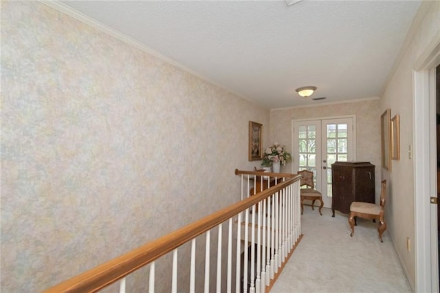 corridor featuring an upstairs landing, carpet floors, ornamental molding, and french doors
