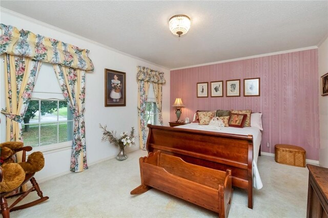 bedroom featuring carpet flooring, a textured ceiling, and crown molding