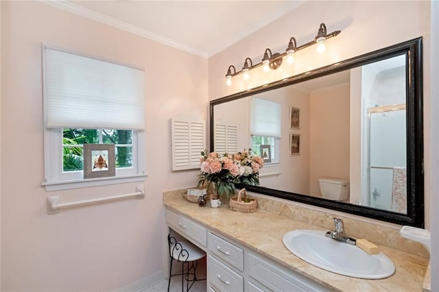 bathroom with toilet, crown molding, vanity, a shower with door, and baseboards
