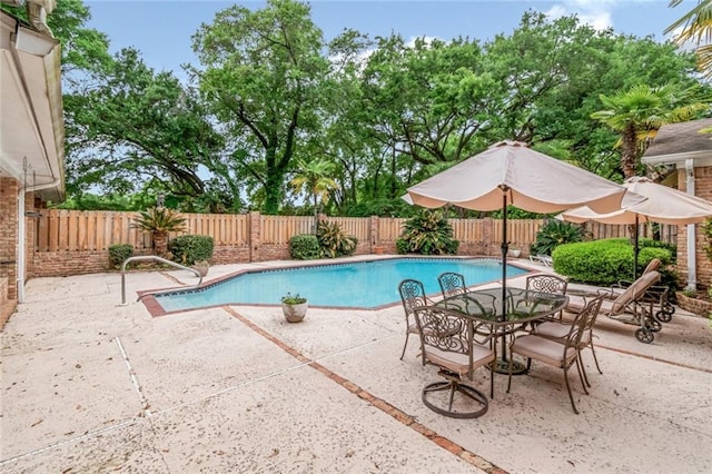 view of pool with a patio area, a fenced in pool, outdoor dining space, and a fenced backyard