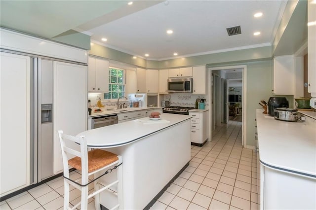 kitchen featuring appliances with stainless steel finishes, a sink, visible vents, and light countertops