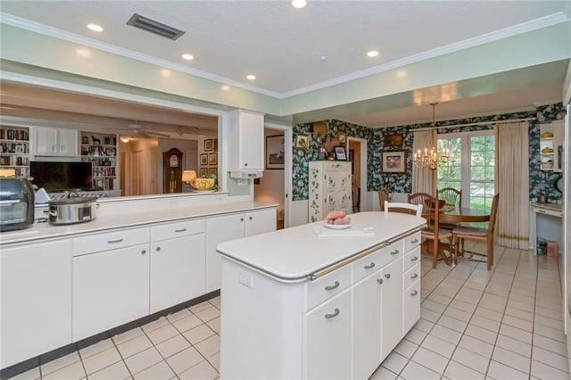 kitchen with an inviting chandelier, light countertops, visible vents, light tile patterned floors, and a center island