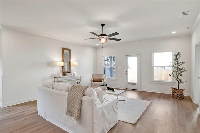 living room with crown molding, light hardwood / wood-style floors, and ceiling fan