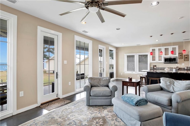 living room with dark wood-type flooring and ceiling fan