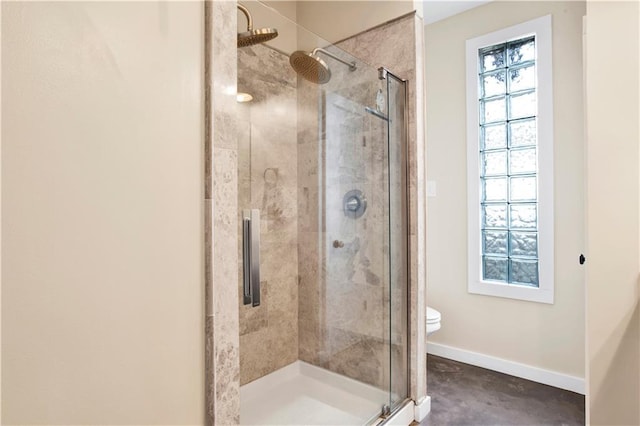 bathroom with a shower with door, a wealth of natural light, and toilet