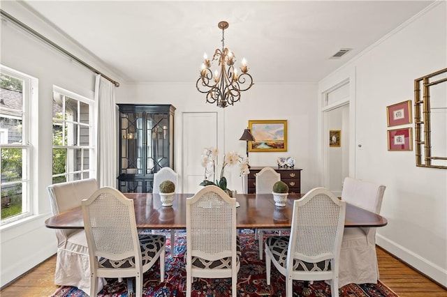 159 Roberts St, Mobile, AL 36604 - dining area featuring a chandelier, plenty of natural light, wood finished floors, and ornamental molding